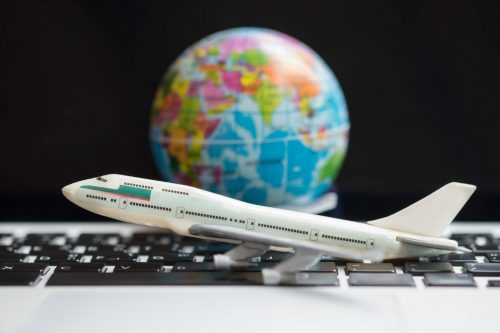 Travel,Concept.,Airplane,Model,Toy,On,Laptop,Computer,With,Mini